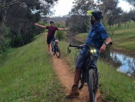 Two people on bikes paused while riding a berm